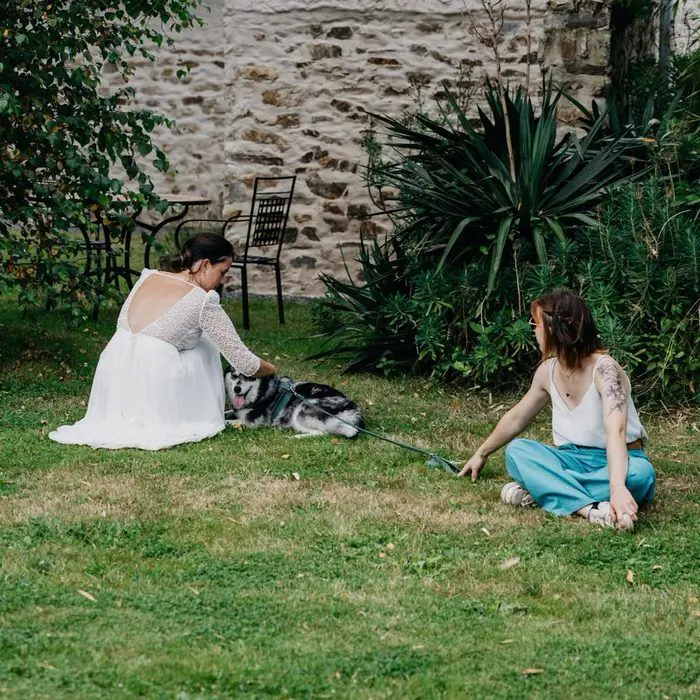 Juliette et une mariée assises dans l'herbe avec un chien
