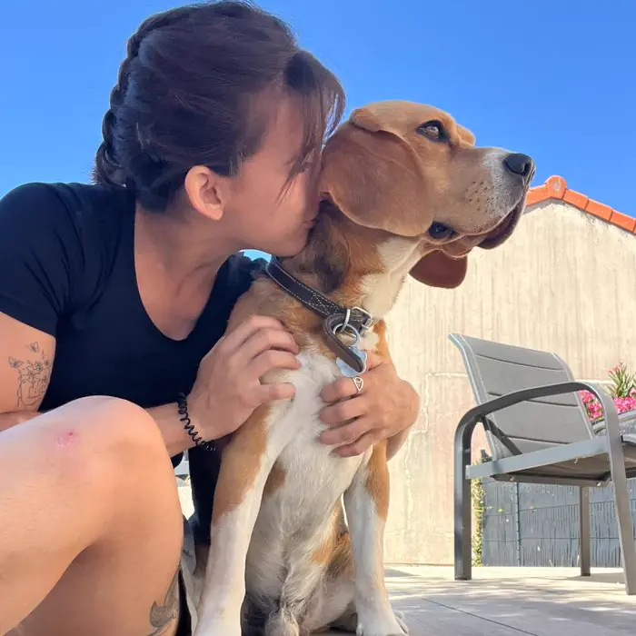 Femme embrassant un beagle qu'elle tient dans ses bras