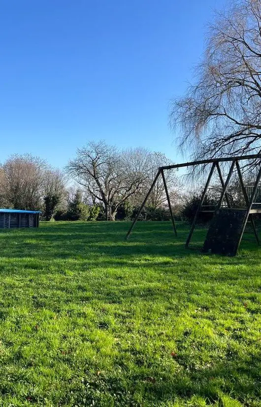 Le jardin de La Vallée Dyr, avec sa pelouse, son portique et sa piscine