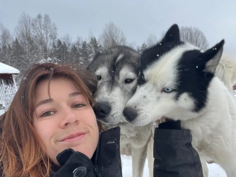 Selfie de Juliette dans la neige avec deux huskies blottis contre elle